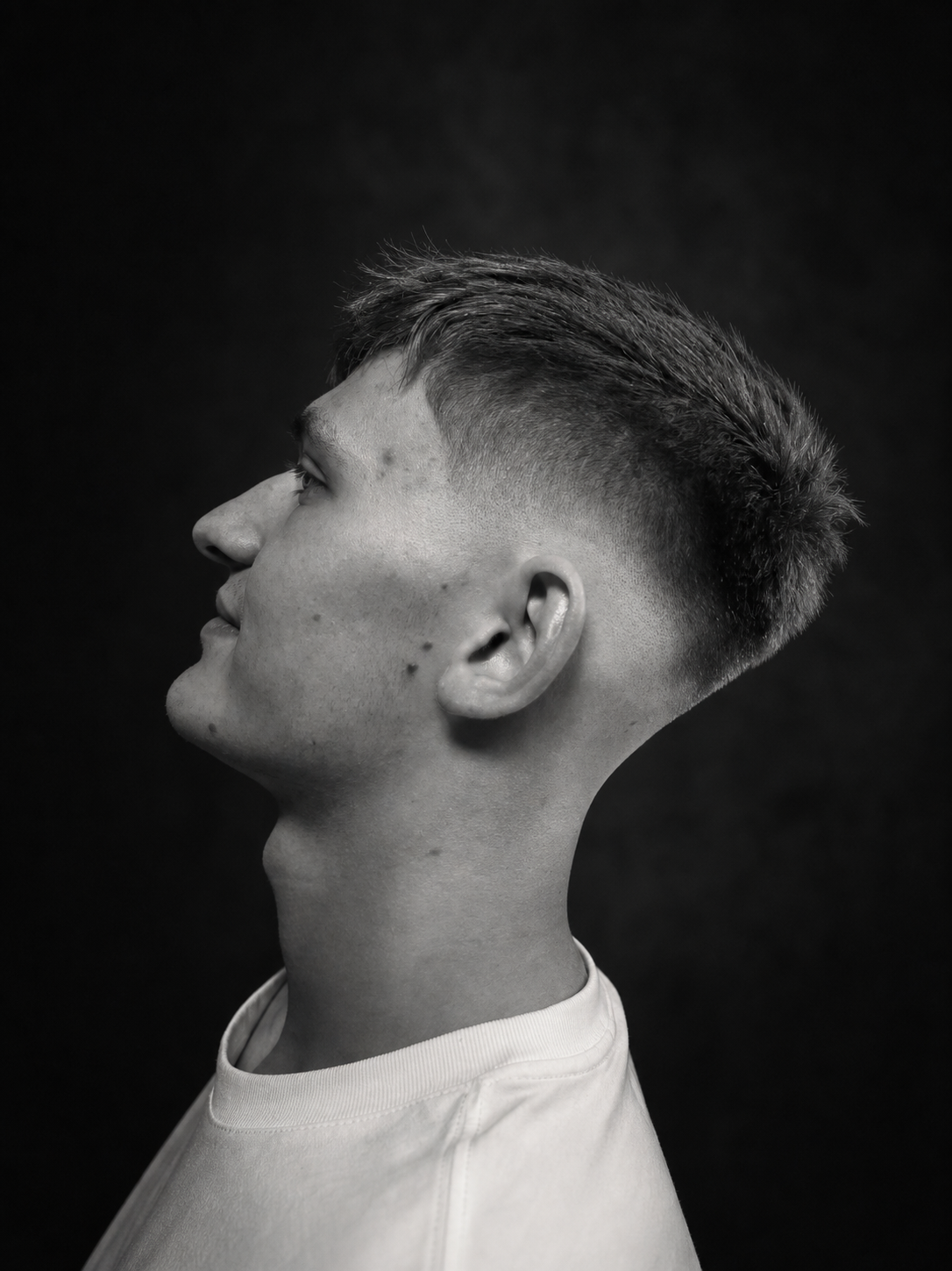 Černobílý detail moderního pánského fade střihu